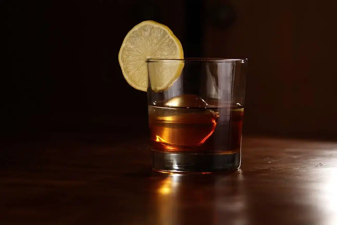 a glass with a drink and a slice of lemon